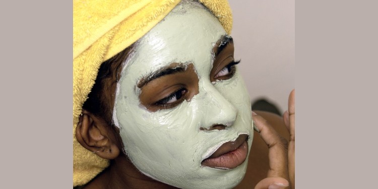 Young woman with avocado mask on her skin
