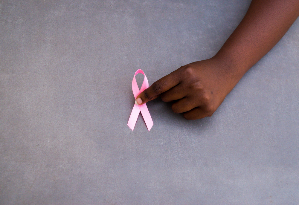 Woman holding the pink ribbon in commemoration of World Cancer Day