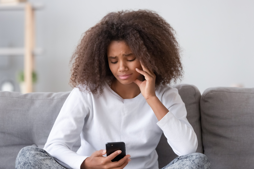 Upset woman looking at her phone screen