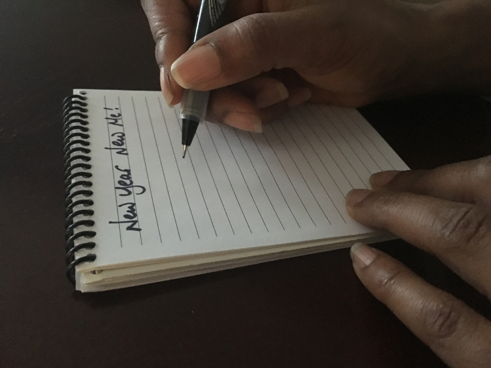 Image of a woman writing down her new year resolutions