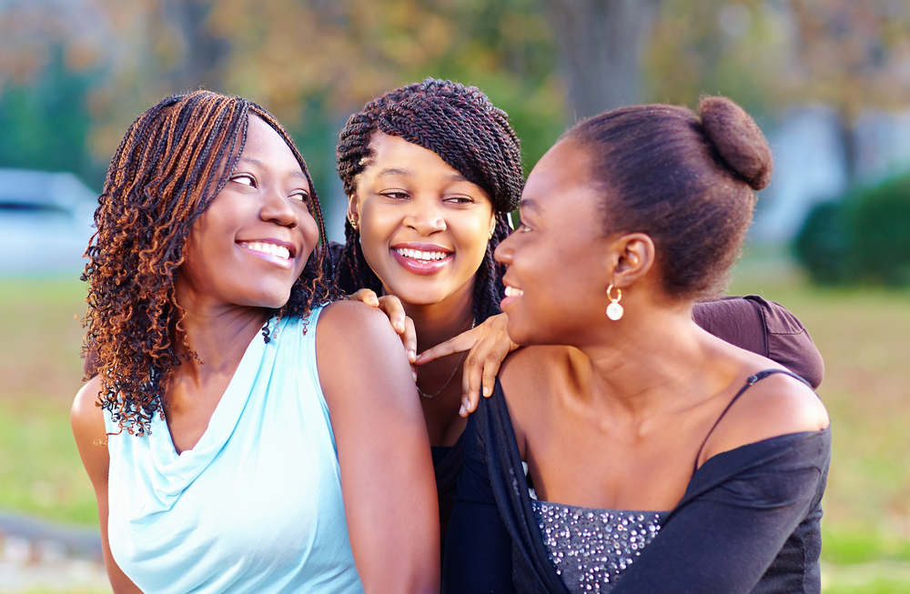 Three Black Female Friends Smile at Each Other